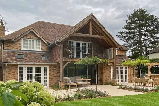 Impressive view of large house with numerous french doors, uses Florence Beige Porcelain on the patio.