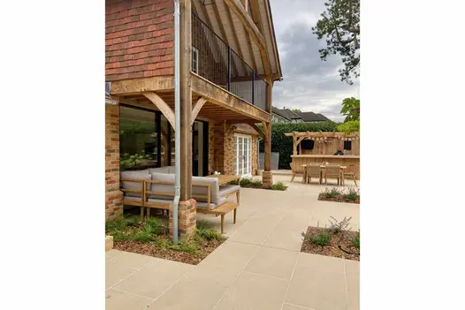 Florence Beige porcelain paving integrated into an outdoor setting with furniture and greenery, offering a warm and inviting atmosphere.
