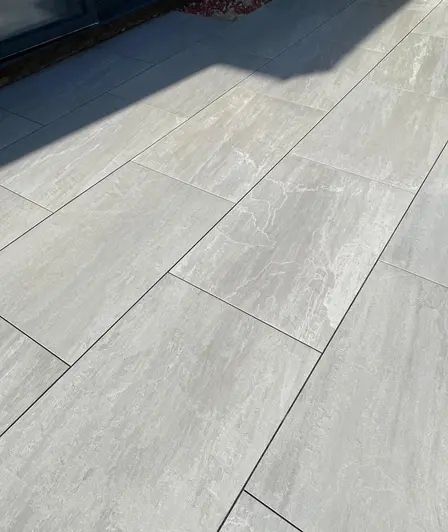 Kandla Grey outdoor porcelain paving, laid running bond by Landspace By Design, shows markings similar to Indian sandstone.