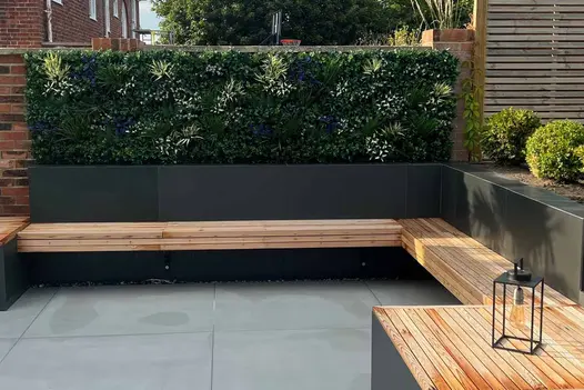 Wooden bench sits around rendered walls clad with opium black luxury designclad with living wall behind.