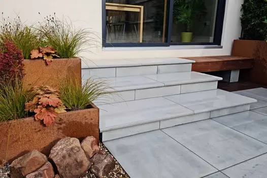 3 bullnose Dove Grey sawn sandstone steps up to sliding patio doors from matching patio. Design by Jane Houghton. Built by Landigo.