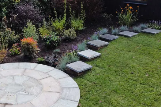 bespoke cut kandla grey indian rock-faced steps as stepping stones, lead away from sandstone circle.