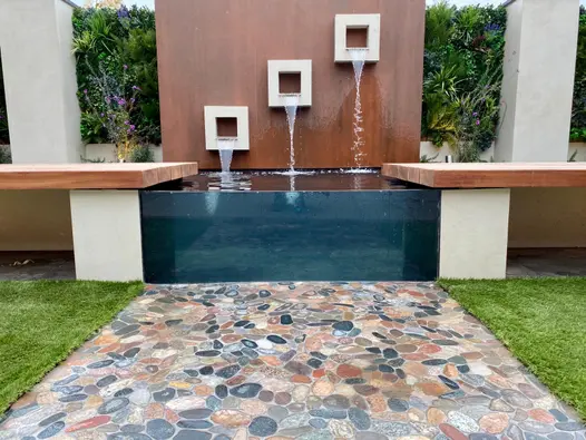 Close up of Vintage Steel Premium DesignClad used in modern garden design with water feature and floating benches.