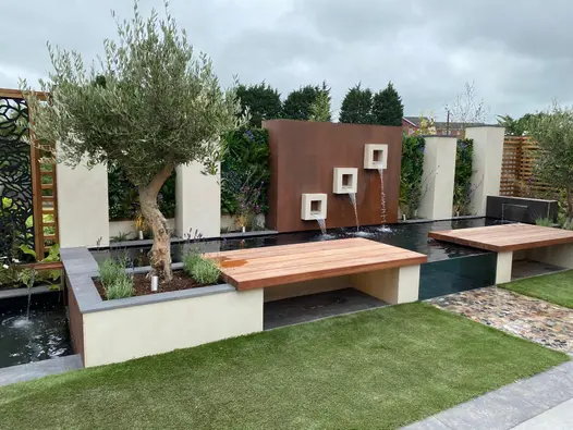 Vintage Steel Premium DesignClad used in modern garden design with water feature, floating benches and olive trees.