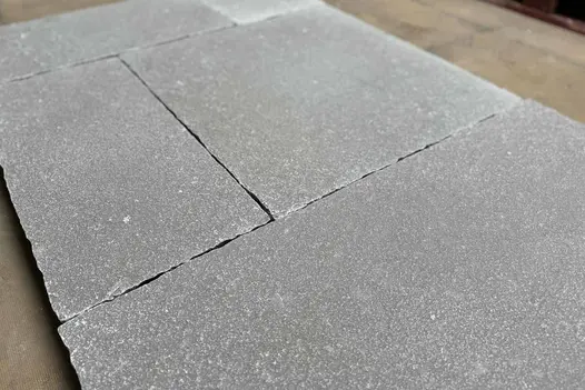 Close-up shot emphasising the rustic elegance and unique character of Antique Grey Limestone paving.