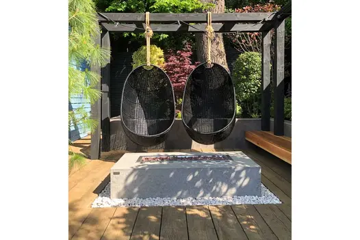 Vintage Millboard Decking in an outdoor setting with two egg chairs over a firepit, adding a warm, rustic touch to the cosy outdoor space.