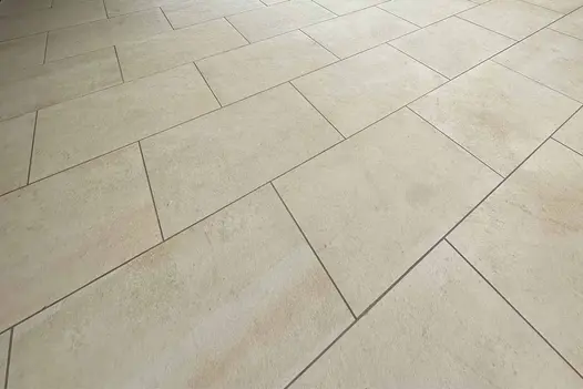Close-up of Mint Porcelain Paving showing beige colour variation and stone-effect surface detail.