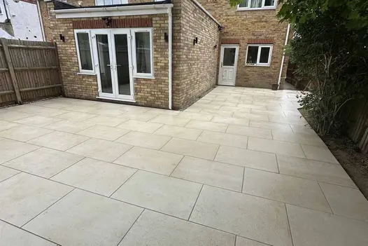 Mint Porcelain Paving wraps around a residential property, paired with timber fencing and soft landscaping.