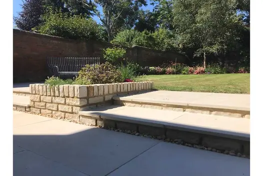 Rectangular block of Mint sandstone walling, with gravel drainage area at base. Built by Brambletye Landscapes.