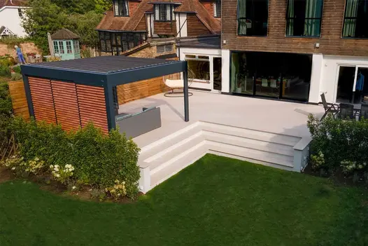 Modern home with Egyptian light porcelain paving patio, matching steps, and structured planting around the edges.