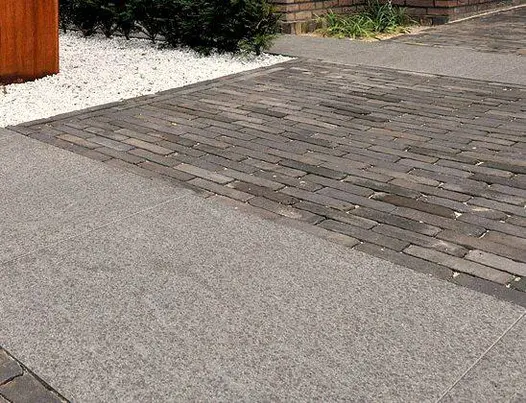 Sections of Moderna clay pavers laid in stretcher bond pattern, interrupted by large mottled grey paving slabs laid in wide strips.