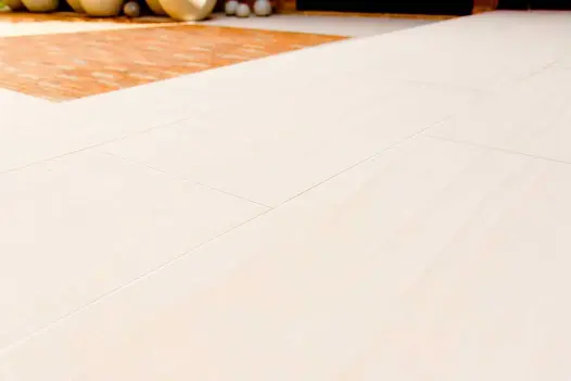 Expanse of Faro porcelain paving, seen from near ground level, with small inset oblong of contrasting clay pavers in background.
