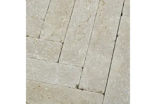 Antique Egyptian Beige Limestone Pavers laid in a classic horizontal brick pattern, highlighting the pale beige surface and natural fossil markings.
