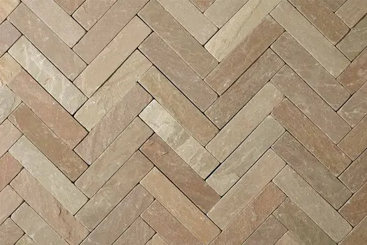 View directly down onto tumbled Raj Green stone pavers laid in herringbone pattern without joints. Free UK delivery available.