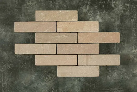 10 Raj Green tumbled sandstone patio bricks laid in 6 rows of 1 or 2 pavers against dark background. Free UK delivery available.