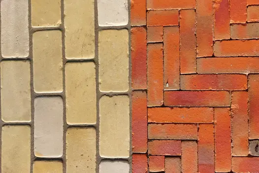 Orange Seville clay pavers laid in herringbone fashion next to pale sawn setts laid running bond. Design by Andy Lewis.