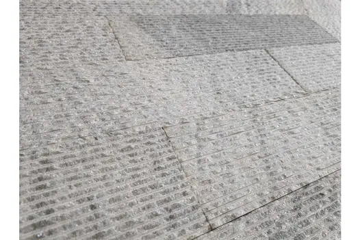 Close-up of Pearl Grey Granite Cladding surface showing its speckled grey tones and fine ridges.