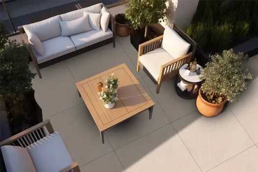 Stylish outdoor terrace using Piazza Beige tiles, with white garden furniture and decorative planting.
