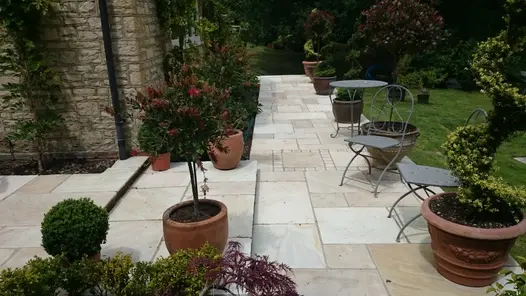 Path of project pack tumbled mint sandstone paving and setts has two wide steps leading to patio and lawn area.