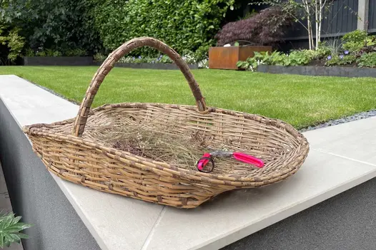 Flower basket sits on corner of Faro porcelain smooth coping on level with lawn, atop retaining wall. Design by Martyn Wilson.