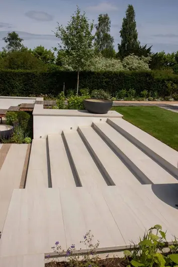 Faro porcelain paving shown alongside garden steps show off the variations in the natural sunlight. Design by Caroline Davy.