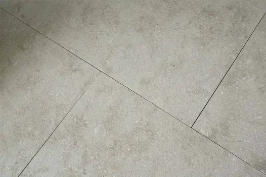 Close-up of Vicenza Sand Flamed Limestone paving, showing consistent colour tones and light surface movement.