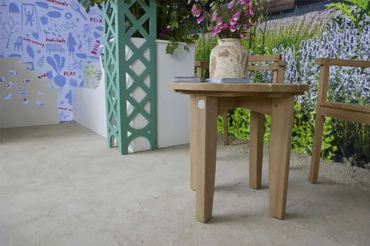 Vicenza Sand Flamed Limestone paving in a Chelsea Trade Stand with timber furniture and planting detail