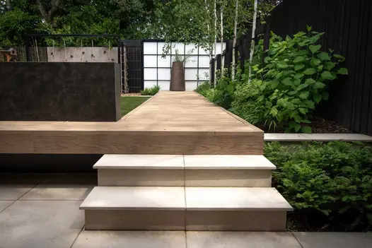 2 Slab Khaki porcelain steps with 5mm chamfered edge rise to decking path between lawn and border. Design by Robert Hughes.