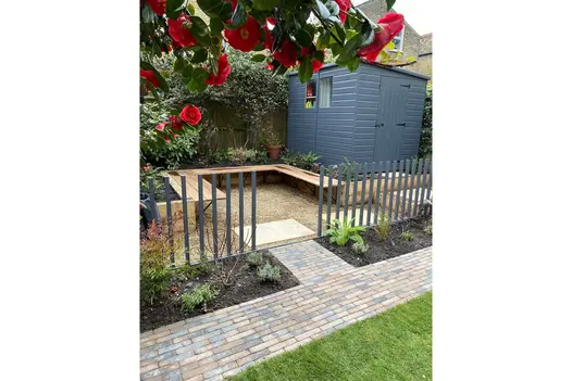 Aldridge Clay Paver path runs to fenced area with shed, paved with gravel and sandstone slabs. Design by Robert Jackson Gardens.