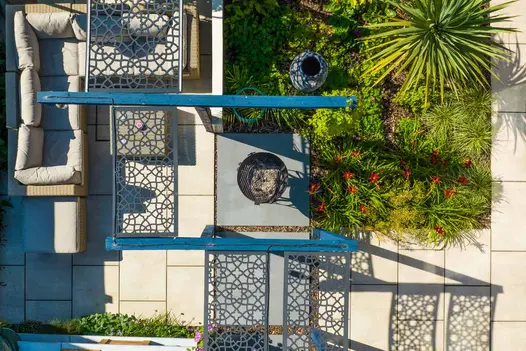Birds eye view of garden design featuring sidewalk 1200x1200 porcelain paving. These large patio slabs create a feature for a firepit.
