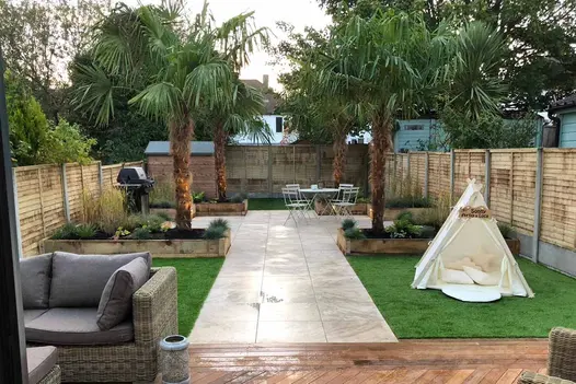 Path of Silver Contro porcelain paving 3 slabs wide runs down middle of garden with lawn and palm tree on either side, shed at end.