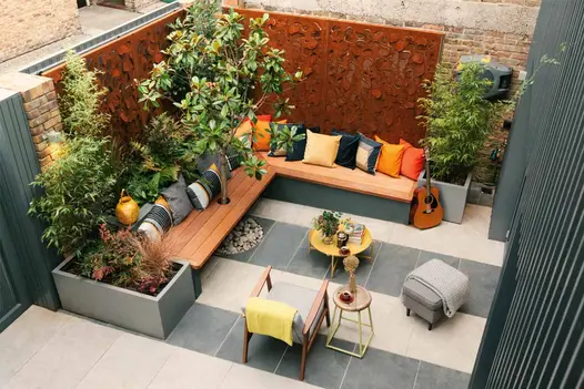 Birds eye view of Georgia Lindsay design using Silver Grey Porcelain Paving beneath corner bench using bright cushions.