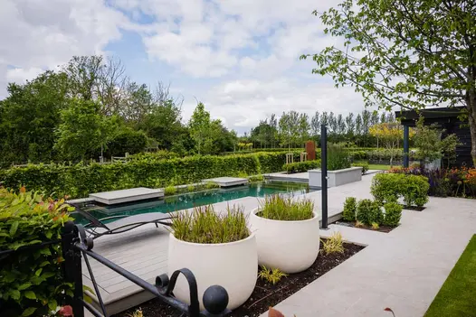 Silver Grey Porcelain paving used beside a modern garden pool surrounded by potted and planted foliage.