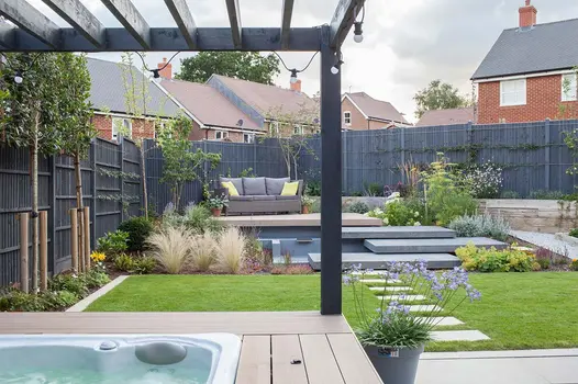 View from hot tub under pergola shows unique multi level garden using mocha designboard composite decking.