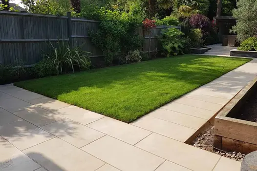 Slab Khaki porcelain path runs around edge of lawn from matching patio to flight of steps. Design by John Gale Landscapes.
