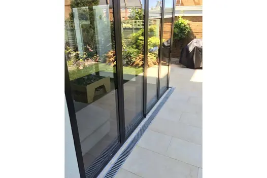 Rectangle Slab Khaki porcelain slabs laid outside a set of bi folding patio doors in a small back garden.
