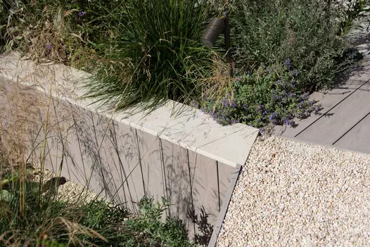Close up of raised wall clad with composite material, slab khaki porcelain used for wall coping with 5mm pencil round profile.