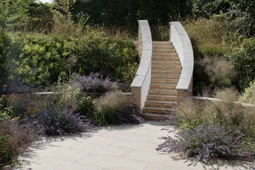 Staircase using golden stone porcelain 5mm pencil round steps, leads up through wildlife away from patio surrounded by lavender and wild flowers