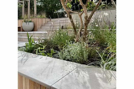 Jura Grey porcelain coping with 40mm downstand edge profile tops raised bed in steeply terraced garden.