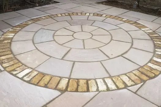 Raj Green natural paving circle edged in contrasting setts set into matching patio pack slabs. Build by Steve Hooper Landscapes