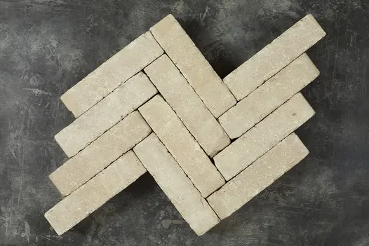 12 Stone Grey clay pavers laid in herringbone pattern in 4 rows of 3 bricks, showing pale buff and white tones. 