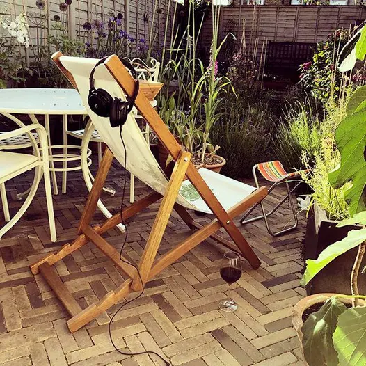 A lounge chair with headphones resting on it, with Aldridge clay pavers serving as the elegant and durable patio flooring.
