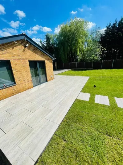 Travertine Dark porcelain patio coming off the back of the house and leading onto a lawn with porcelain stepping stones.