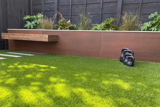 Three weights lined up on grass next to raised flowerbed clad with vintage steel premium designcald.