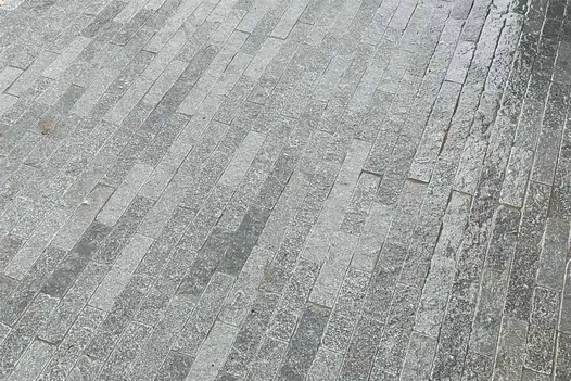 Glistening surfaces of Wet Antique Grey Stone Pavers reveal intricate patterns and subtle variations, and a range of grey tones